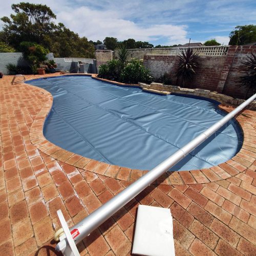 bâche solaire installée sur une piscine enterrée